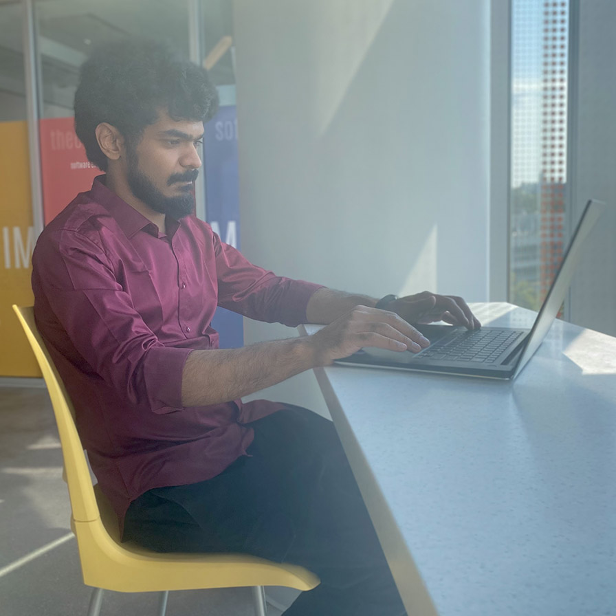 Jamshed working at a desk with laptop