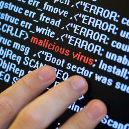 Fingers pointing to screen with the words "malicious virus" along with some code