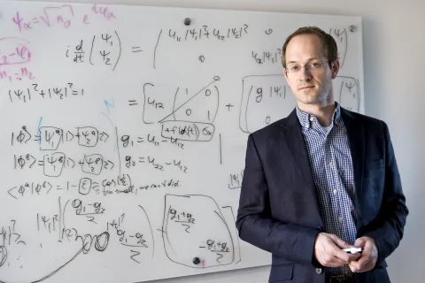 A photo of Andrew Childs in front of a whiteboard 