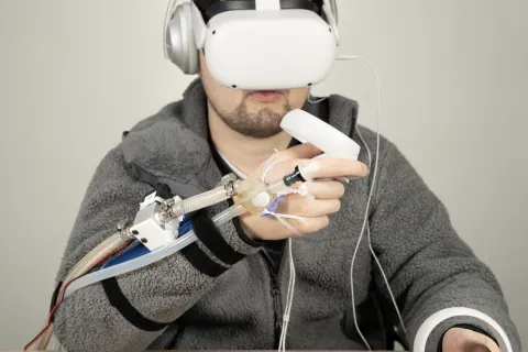 Photo of a person wearing a VR headset and the JetUnit attachment