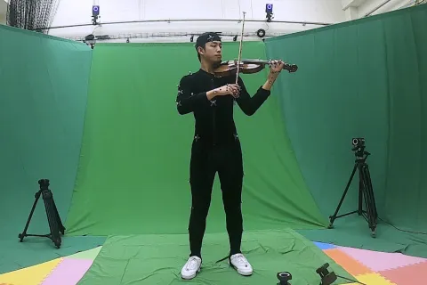 person playing violin against greenscreen