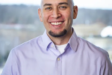 bald man in purple shirt