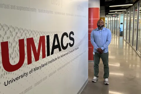 man standing by UMIACS sign