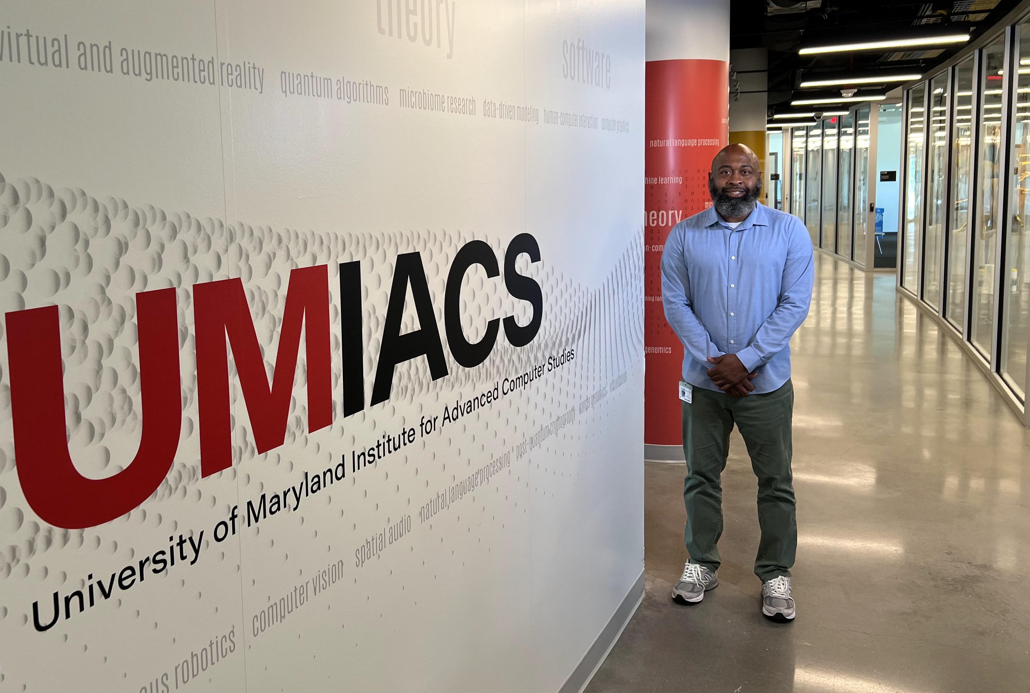 man standing by UMIACS sign