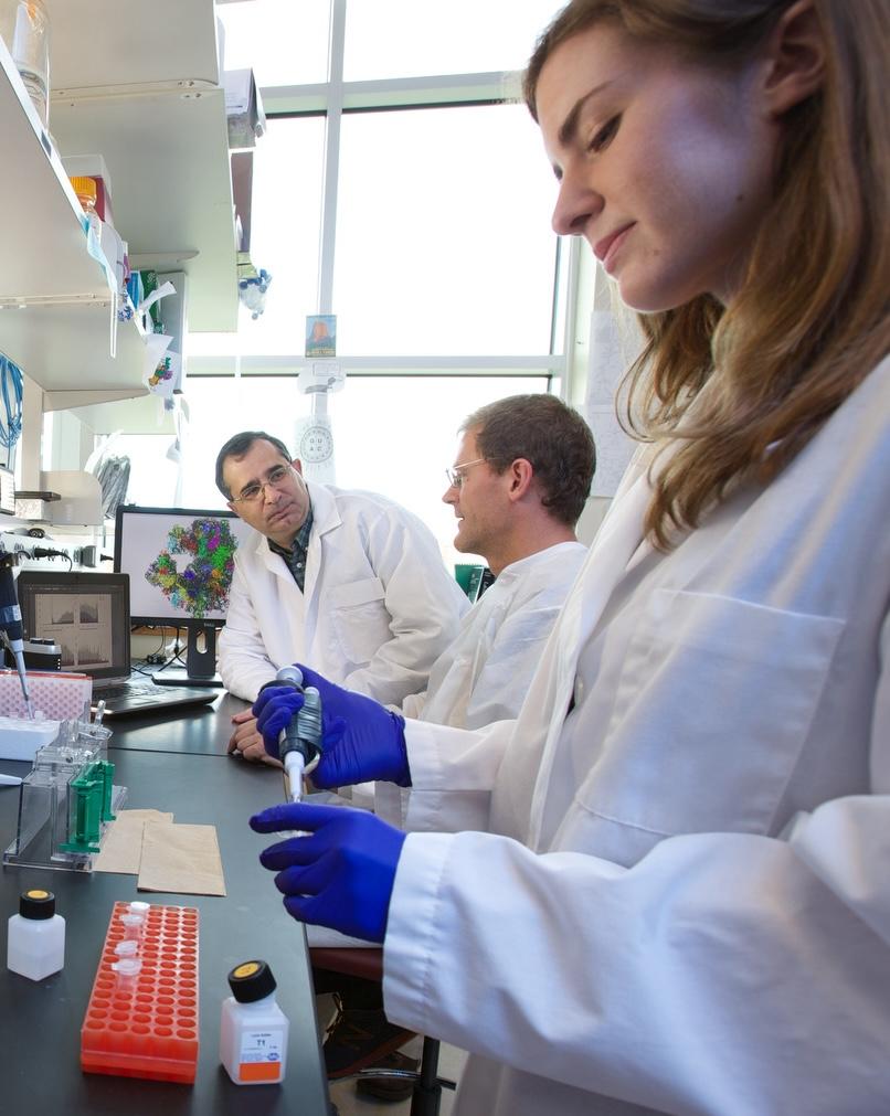 researchers in white lab coats with equipment