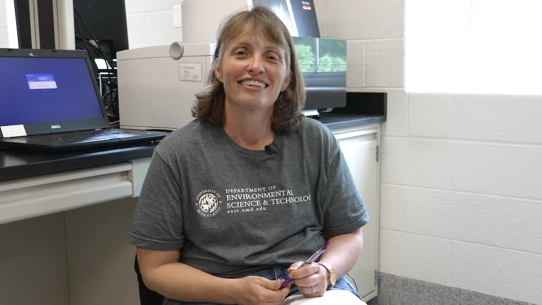 Stephanie smiling in lab wearing department T-shirt