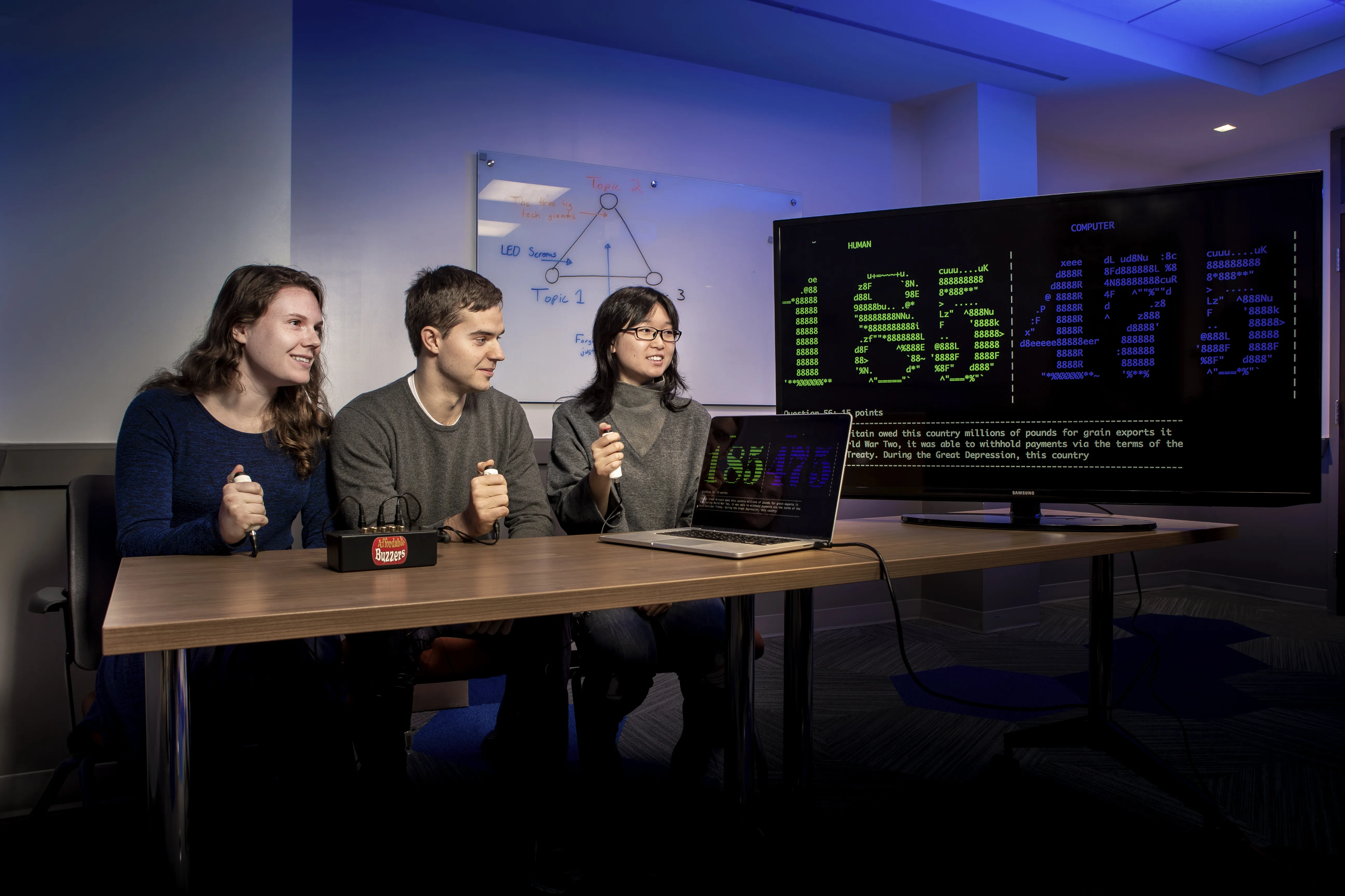 three students playing trivia against computer